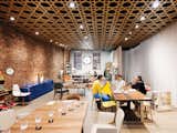 Team 7’s leather Aye Armchair is placed adjacent to it's Flaye dining table (left). Michael, Anna, and a client sit at a table by Galerie Holzer. The yellow and gray chairs are by Hussl.  Photo 5 of 5 in A New York Shop with Austrian Design Sensibility