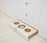 In addition to housing storage, the staircase also hides pet food bowls.  Photo 5 of 10 in A Renovated Tribeca Loft with a Modern Aesthetic by Monique Valeris