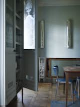 The bespoke sideboard (hiding the stairway to the basement) and the kitchen table were both built from wood sourced from a school science laboratory, while the sliding door that fronts the sideboard was salvaged from the National Museum of Scotland.  Photo 2 of 12 in A Gracious London Terrace House Is Reborn with Salvaged Materials