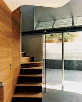 Langston-Jones doubled the outdoor space by combining the back patio of his unit and that of his neighbor. A small screen of gracilis, or weaver’s bamboo, and Rhapis palms provides privacy between the courtyards while still remaining relatively transparent. “When funds allow, a stainless steel chain-mail ‘curtain’ will be suspended from the roof structure to provide further privacy,” the architect notes.  Photo 3 of 9 in Twice as Nice