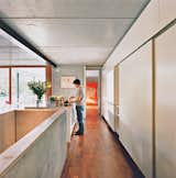 Kitchen, Concrete Counter, and Medium Hardwood Floor Meili makes tea in the kitchen. The Living Tower by Vernon Panton is in the background.  Photo 1 of 238 in Interiors by Allison Hilborn Tatro from Swiss Mix