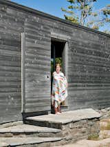 Emma Worple dries off from a swim at the cedar-clad sleeping cabin; the door slides shut to shield the cabin from harsh winter winds.