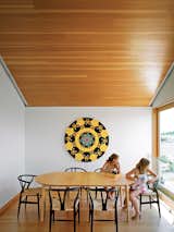 Dining Room, Table, Medium Hardwood Floor, and Chair Emma Worple and a friend enjoy an open view of the island from the dining area.  Photo 13 of 16 in A Floating House on Lake Huron Stands Out By Blending In