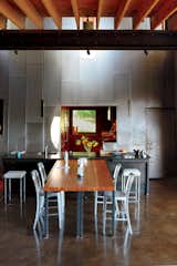 A custom recycled-Douglas fir table by VanEyk Custom Woodworks is the heart of the living-dining room in the so-called "Scrap House." The double-height wall is clad in the same steel that wraps the exterior. Read the full article here.  Photo 2 of 8 in Scrap House