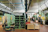 The factory contains a wide array of hydraulic presses. The cagelike bins hold groups of cold-pressed objects left ready for the next phase of production. Alessi's facility manufacture fifty-thousand 9090's per year.