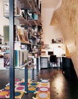 Custom-fabricated modular bookshelves create a corridor leading to the home office.