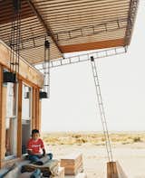 Nicholas sits in the shade of the roof; students cut and hand-welded thousands of reclaimed rebar pieces into a complex grid that would support four bi-level 

corrugated-steel roof panels.