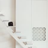 Mikulionis custom designed the white steel staircase that leads from the living area up to the bedroom platform.