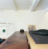 The platform bed was designed by the architect. The pattern on the ceiling was drawn by Rasa Baradinskiene, a local designer, in colored pencil over the off-white paint. Mikulionis and Marcinkeviciute don’t worry about slipping through the rails to the living room level below.
