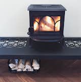 The wood stove roars atop a table designed by the architect.