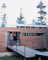 Exterior, Metal Roof Material, Flat RoofLine, House Building Type, and Wood Siding Material Galvanized steel is used to bridge the gap between natural landscape and structure in the entryway of the house.  Search “Mind-the-Gap.html” from Washington State Vacation Home Sets the Stage