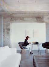 With bright red hair, Hill is a standout in a gray-glass 1960s building. Her coffee table is a French mail-sorting table with the legs cut down.  Photo 6 of 11 in Stripped Ease