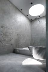 This coolly modern sanctuary in Denmark echoes the elegant austerity of resident Nick Zappon's films. The master bathroom was constructed in concrete with a circular bathtub and accompanied by a parallel circular cutaway in the roof that allows contemplative bathers to view the stars from the tub.