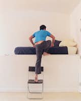 Jeremy Claud ascends to his bed, which is on a raised platform that hovers over a staircase.