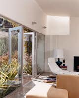 Seven-foot-high glass doors bring the garden, landscaped by Jay Griffith, into the living room. A skylight brings even more light into the white-walled room with polished-concrete floors. There is a splash of color in a custom rug designed by Dawn Farmer and made by Della Robbia, which also made the sofas.