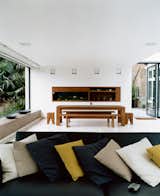 The new space was conceived as a blank canvas so that the decidedly nontraditional English garden—a large lawn bordered by exotic palms, bamboos, ferns, and other flamboyant foliage inspired by a recent holiday to Australia—could be the focal point. The minimalist dining table, benches, and stools are by e15.