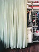 The contents of the 15-foot-long closet are concealed by a long swath of calming blue-green fabric that glows like a light box when illuminated from within.