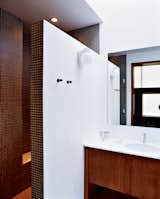 Bath Room, Marble Counter, Enclosed Shower, Full Shower, Ceiling Lighting, and Ceramic Tile Wall A double-size shower, clad floor-to-ceiling in tiny earth-toned tiles, was built after relocating the water heater and claiming its space. A chic yet discreet toilet is wall-hung and the tank concealed, greatly ameliorating the somewhat claustrophobic feel of the original bathroom.  Photo 5 of 6 in The Pace of Portland