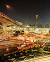 The city’s bustling nightscape is captured from a footbridge at the Victory Monument.