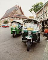 Perhaps the most sweetly named mode of transportation, a group of Tuk Tuks park outside the Grand Palace.  Photo 7 of 12 in The Bangkok Beat