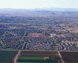 Countless housing developments crowd the periphery of the area’s remaining farmland. The developments are broken up into self-contained units. Typical to sprawl, the work and service sectors are accessible only via highway.  Photo 6 of 6 in Razing Arizona