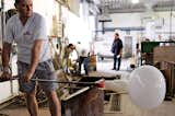 Once the Glo-Ball has received its final shape from the mold, a worker spins the translucent glass to continue cooling and to check for any imperfections or cracks.