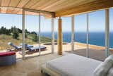 Two walls of floor-to-ceiling windows in the master bedroom frame expansive vistas of the Pacific Ocean.