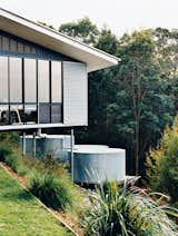 Outdoor and Grass The studio is clad in corrugated tin, echoing the adjacent water-storage tanks, which collect and filter rainwater off the roof.  Photo 7 of 12 in Hillside Family Home in Australia