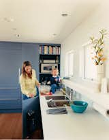 Julie enjoys her new kitchen with son Emerson. She wanted to conceal as many appliances as possible, so Deam disguised the Sub-Zero refrigerator and Miele dishwasher with panels from Downsview Kitchens that match the cabinets, giving the kitchen a clean, uncluttered appearance.