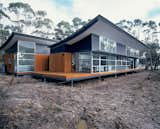 With its bold, upswept profile, the roof gives this otherwise simple house its distinctive character. But those curves are not merely for show. The concave forms are integral to the dwelling’s self-sufficiency because they act as water collectors and sun protection. When rain hits the roof, it runs down into holes punched into the valleys created by the tilt of the corrugated-steel sheets. Underneath these holes, which are too small for leaves to penetrate, the water collects in a concealed gutter and is piped down the side of the house and underground to the nearby water tanks. Using a combination of computer technology and onsite observation, the architects calculated how far the main roof would have to overhang the north elevation to let in as much low winter sun as possible, while shielding the interior from the more extreme summer sun. The nearly 13-foot-high expanse of glazing that embraces the views really needed protecting—and the four-foot eave created by the sweep of the main roof does the job well.