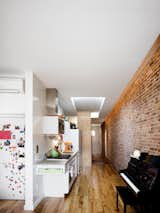 For a nine-year-old who loves pirates and science fiction, Jonah Finger thinks of his family’s apartment as make-believe come true. His parents, Michael Finger and Joanne Kennedy, completed the renovation of their 640-square-foot walk-up in Manhattan’s East Village in May of 2008.&nbsp;The kitchen sits along one wall of the connective passage between the living room and the rear of the apartment. Finger had initially envisioned an all-black, showroom-style kitchen, but ultimately they went with CaesarStone and a gray color scheme, which kept the kitchen from dominating. Though the area is narrow, there’s still enough room for Jonah to set up a battleground for several  brigades of army figurines near his father’s collection of lime green Le Creuset pots. Pantry goods are stored in a narrow sliding shelving unit that doubles as a screen when extended fully.