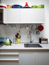 In the kitchen, colorful cookware accents white surfaces.