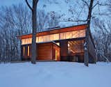 The house is wrapped on three sides with a rain screen of weathering steel panels. On the northern facade, a clerestory window lets in light to illuminate the inside spaces.