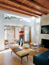 Architect, builder, and developer Jeremy Levine stands at the threshold of the front deck and the living room under his newly raised ceiling made of wood recycled from the original pitched roof.  Photo 1 of 10 in Casa Study House #1