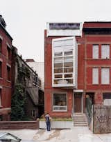 As part of a major renovation of a turn-of-the-century brick row house in New York City's Harlem neighborhood, architect Laura Briggs made a bold change to the formerly historical facade by adding a projecting, multi-floor oriel window to the front elevation. The original brick facade had partially collapsed after fatefully getting struck by lightning, and the new window's industrial materials (like metal siding) give it a distinctly modern edge that's unlike anything else seen on the block.