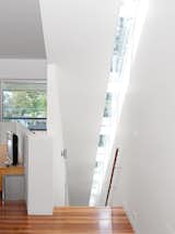 Thin skylights running atop the full length of the staircase illuminate the trip up the side of the house.