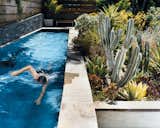 Day takes a swim in a new lap pool framed by a lush Southern California garden. The lower wall next to the pool is made from stacked Pennsylvania bluestone, which was used for all exterior stone as well.