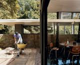 Outdoor, Large Patio, Porch, Deck, and Stone Patio, Porch, Deck In his writing geared toward builders, A. Quincy Jones encouraged using large panes of glass and sliding doors to bridge the exterior and interior. Here, Nick Roberts puts the philosophy to good use for a weekend barbecue.  Photo 2 of 6 in Homes Blending Indoor and Outdoor Living Space by Megan Hamaker from Mutual Fulfilment