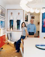 Didier Krzentowski and his wife, Clémence, in the dining room of their Paris flat. The Slim table was designed by Martin Szekely for a Galerie Kreo exhibition in 1999. On the wall, above a Marc Newson Alufelt chair, is a photograph of Krzentowski by Erwin Wurm.  Photo 1 of 14 in Like a Kid in a Candy Store