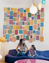 Clémence and daughter Clara, nine, relax on a purple Pierre Paulin 261 sofa below an installation by artist Alan McCollum. A small family of Verner Panton 1969 Wire lamps, featured in the inaugural Kreo exhibition, live to the left.