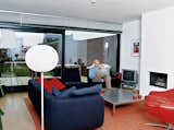 Living Room, Sofa, Chair, Light Hardwood Floor, Standard Layout Fireplace, and Floor Lighting In the living room, Caspar educates his young son Roemer about the finer points of modern design. The red leather Gigi is van den Berg’s racy yet refined swivel armchair. Looking at this chair, it comes as no surprise that the designer drives a Porsche. “It’s from the late ’90s, but it’s already a classic,” says Caspar. “I just love the versatility of this one—you can sit forwards or sideways in it.” Van den Berg also designed the stainless-steel coffee table. The purple sofa was designed by Rodolfo Dordoni, and the Glo-Ball lamp is by Jasper Morrison.  Photos from Furniture Fascination