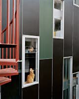 Rich, dark concrete panels and colorfully dispersed windows wrap the exterior in varying permutations.