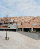 The wood-clad balconies of the private side of the building offset the futuristic punched-metal mural of Mount Everest on the facades facing the Metro tracks. "It's a schizophrenic sensibility," Ingels says. "The south is purely organic, and the north is strictly contemporary."  Photo 5 of 20 in Mountain Dwellings Urban Development in Copenhagen
