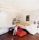 Nora, the architects' six-year-old daughter, hangs out next to her built-in bed.