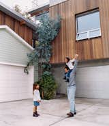 The architect with his daughters. The redwood strips on the new house were purposely cut to the same width as the horizontal wood siding on the old house to create visual harmony between the two.
