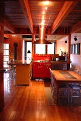 “The idea of the house is to constantly flip-flop between modern and vintage,” Moore says. In the kitchen, the new poured-in-place concrete countertops are complemented by vintage stools and a red stove (made the same year, 1923, in which the original house was built) that Moore found online and then refurbished. "We wanted to make it so that people would have no idea what's new and what's old," he says.

Photo courtesy of Mike Moore/Tres Birds Workshop