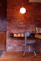 On the main floor, opposite the pantry, a corner of the central brick core is used as a home office. Moore designed and built the desk.

Photo courtesy of Mike Moore/Tres Birds Workshop