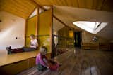 On the top floor, the children’s bedrooms flank the front and back sides of the stairwell. Moore and his team poured the amber-colored resin wall in a mold before raising it to the back of the bed to to separate the it from the stairs.

Photo courtesy of Mike Moore/Tres Birds Workshop
