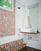 Bath Room, Mosaic Tile Wall, Wall Mount Sink, and Vessel Sink Robertson--with the help of developers Katie Nichols and John Walker, who were heavily involved in the design process--finished the guest bathroom with Modwalls tiles and a sink they found on eBay. They used a piece of marine plywood, leftover from building the front-porch steps, to create a counter on which the sink could sit--and where the family can rest their toothbrushes. To the right of the sink is a Toto dual-flush toilet, which is great for conserving water but has proven problematic for toilet training, as American potty seats aren't designed to fit these Japanese basins.  Search “아산오피【OP030,com】그렘의상ꆖ아산오피➭아산스파ᕶ아산키스방ꃒ아산OPᔔ아산풀싸롱Գ아산업소” from The Shipping Muse