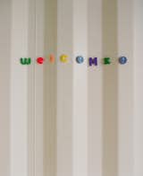 The corrugated steel of the side of the container that houses the master suite becomes a textured wall for writing messages in the entrance of the home. "When we were furnishing the house, I thought, 'Oh no! Our fridge isn't magnetic for Eli's artwork,' but then I realized the whole house is magnetic," Feldmann says. "We've become magnet connoisseurs," Freeman adds.  Photo 17 of 22 in The Shipping Muse